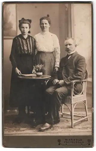 Fotografie W. Arnold, Freyburg a. U., Bürgerliches Paar mit Tocher in eleganter Kleidung