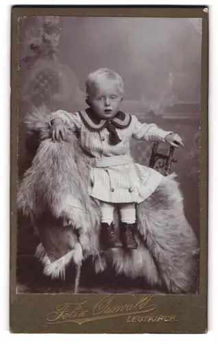 Fotografie Felix Osswald, Leutkirch, Kleiner Junge im Kleid sitzt auf einem Fell