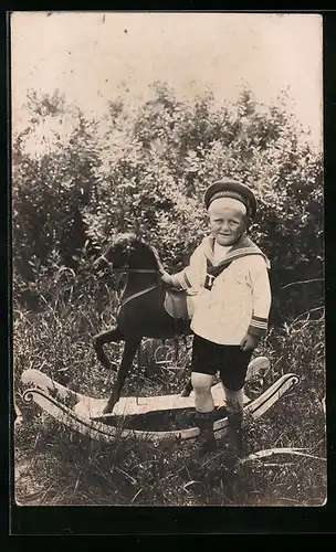 Foto-AK Kleiner Junge in Matrosenkleidung mit einem Schaukelpferd