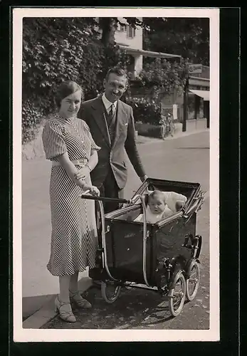 Foto-AK Junge Eltern mit Baby im Kinderwagen auf einer Strasse