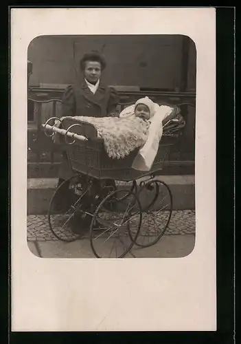 Foto-AK Junge Dame mit Baby im Kinderwagen auf einem Bürgersteig