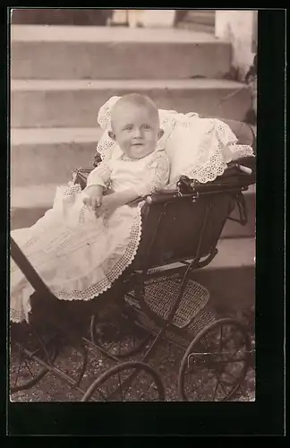 Foto-AK Lächelndes Kleinkind im Kinderwagen vor einer Steintreppe