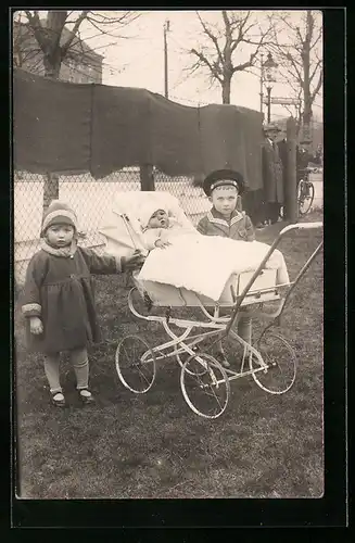 Foto-AK Junge und Mädchen mit Baby im Kinderwagen auf einem Rasenstück