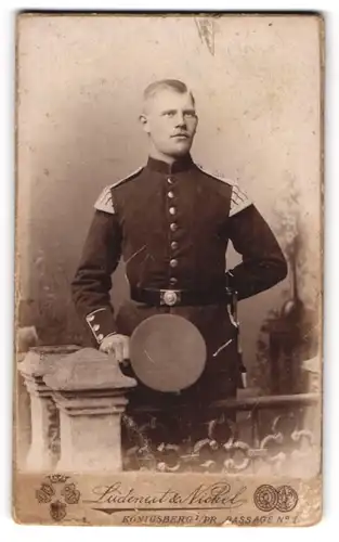 Fotografie Ludeneit & Nickel, Königsberg, Passage 1, Musikcorps-Soldat in Uniform mit Schwalbennestern und Bajonett