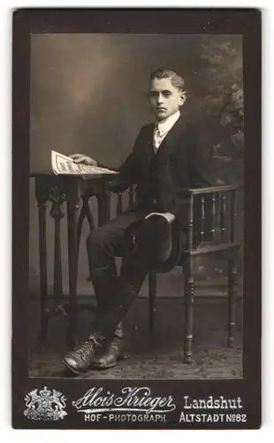 Fotografie Alois Krieger, Landshut, Altstadt 82, Jüngling mit Zeitung an einem Tisch