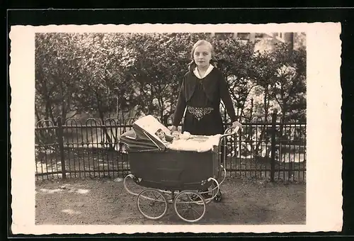 Foto-AK Junge Frau mit einer Puppe im Kinderwagen
