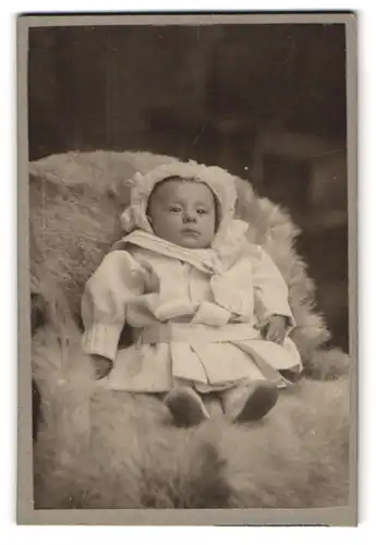 Fotografie Louis Becker, Essen, Einhornstr. 3, Kleinkind im Kleid sitzt auf einem Fell