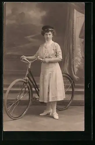 Foto-AK Dame mit grimmigen Blick und Fahrrad