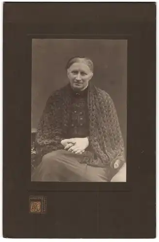 Fotografie A. Köster, Hagen / Westfalen, Bahnhofstrasse 33, betagte Dame mit Decke im Foto-Atelier sitzend