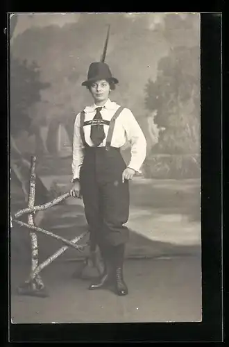 Foto-AK Junge Frau in Trachtenhose in einer Studiokulisse
