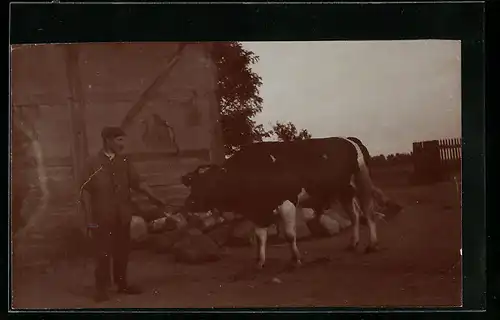 Foto-AK Bauer mit seinem Ochsen neben einem Gebäude