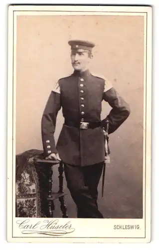 Fotografie Carl Hüseler, Schleswig, Stadtweg 147, Soldat des Musikcorps in Uniform mit Bajonett und Schwalbennestern