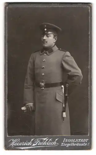 Fotografie Heinrich Fröhlich, Ingolstadt, Ziegelbräustrasse 1, Junger Soldat im Mantel mit Bajonett und Portepee