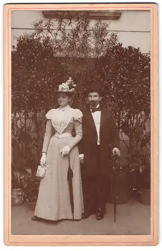 Fotografie unbekannter Fotograf und Ort, Junges Paar in eleganter Ausgeh-Kleidung in einem Garten