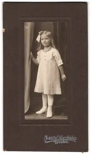 Fotografie Martin Herzfelde, Dresden, Vergnügtes kleines Mädchen im hellen Faltenkleid