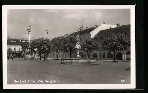 AK Bruck a. d. Leitha, Hauptplatz mit Eisen-Handlung, Brunnen und Denkmal