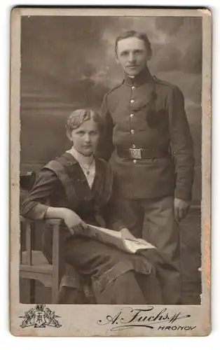 Fotografie A. Fuchs, Hronov, Jiraskova Ulice, Junger Soldat in Uniform mit Schützenschnur und Bajonett nebst Gattin
