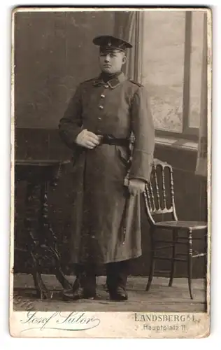 Fotografie Josef Sutor, Landsberg a. L., Hauptplatz 11, Soldat in Uniform mit Mantel und Bajonett