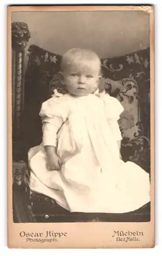Fotografie Oscar Hippe, Mücheln, Niedliches Baby sitzt auf Stuhl