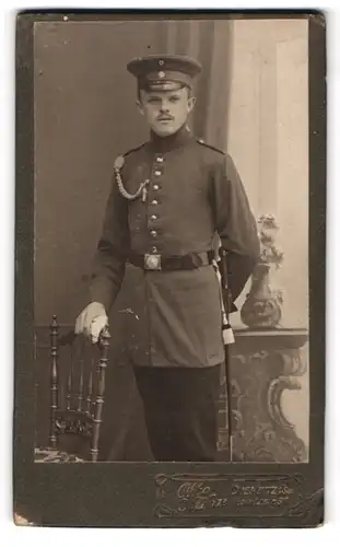 Fotografie Otto Kühn, Chemnitz i. Sa., Planitzstr. 90, Soldat in Uniform mit Schirmmütze u. Schützenschnur