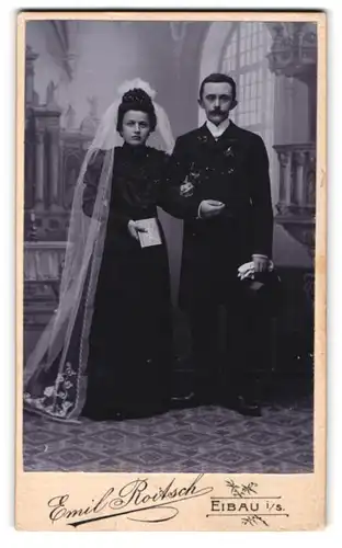 Fotografie Emil Roitsch, Eibau i. S., Eheleute im schwarzen Hochzeitskleid und Anzug mit Schleier und Zylinder