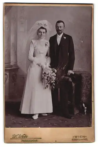 Fotografie W. Weis, Wien, Hauotstr. 67, junges Brautpaar im Hochzeitskleid und Anzug mit Schleier und Zylinder