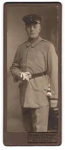 Fotografie Heinrich Petersen, Schleswig, Junger bartloser Soldat in weitem Uniformrock