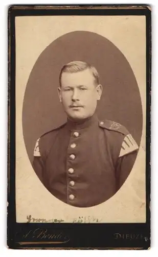 Fotografie Ed. Bender, Dieuze, Kasernen-Weg, Uniformierter Soldat des Musikcorps mit Schwalbennestern, IR 136