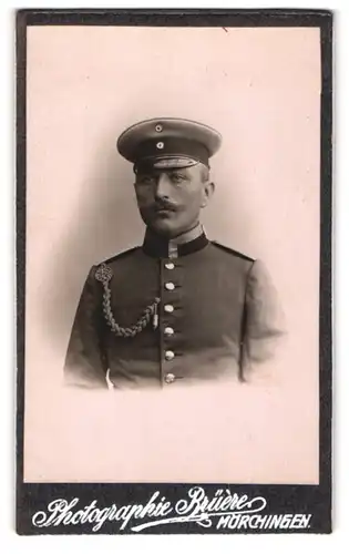 Fotografie Bruère, Mörchingen, Kapellenstr. 41, Soldat in Uniform mit Schirmmütze und Schützenschnur