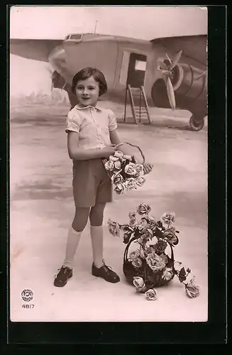 AK Kind mit Blumenkorb vor Studikulisse mit Passagierflugzeug