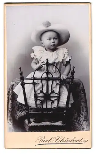 Fotografie Paul Schückert, Charlottenburg, Berlinerstrasse 112, Kleinkind mit breitkrempigem Hut auf einem Sitzmöbel