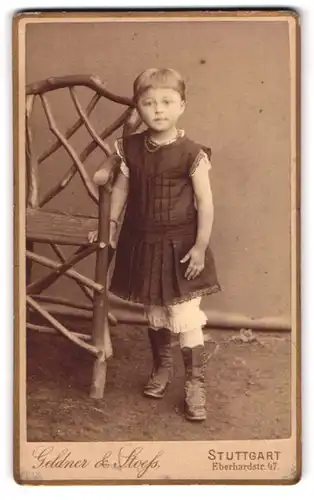 Fotografie Geldner und Stoess, Stuttgart, Eberhardstr. 47, junges Mädchen im Sonntagskleidchen an einer Bank