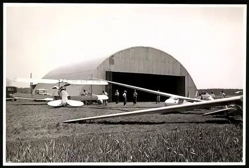 Fotografie Flugplatz, Segelflug, Segelflugzeuge & Doppeldecker-Flugzeug vor einem Hangar