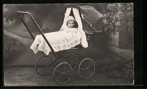 AK Kind in einer Fotokulisse im eigenen Kinderwagen, datiert 1920