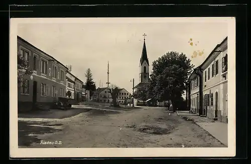 AK Riedau /O.-D., Strassenpartie mit Kirche