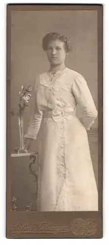 Fotografie Albert Fabinger, Werdau i. S., Dame im Kleid mit Blumenvase