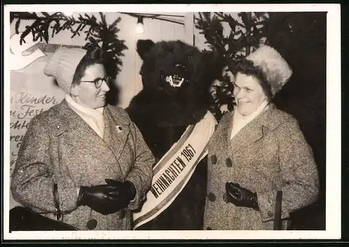 Fotografie Weihnachten 1961, betagte Damen und Bär, Bärenkostüm auf einem Weihnachtsmarkt
