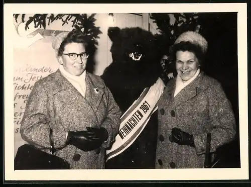 Fotografie Weihnachten 1961, Bär, Bärenkostüm & Damen auf einem Weihnachtsmarkt