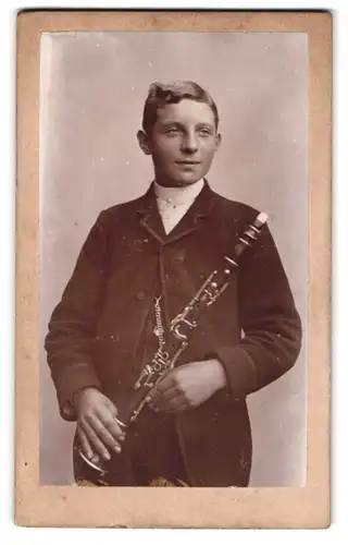 Fotografie unbekannter Fotograf und Ort, junger Knabe posiert mit seiner Klarinette im Atelier