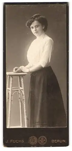 Fotografie J. Fuchs, Berlin, N. Friedrichstr. 108, elgante Dame mit welliger Frisur und schwarzem Rock und weisser Bluse