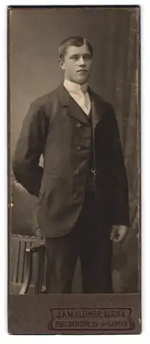 Fotografie J. A. M. Kleiner, Altona, Reichenstr. 26, stattlicher Knabe im schwarzen Anzug mit weisser Krawatte