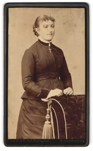 Fotografie Friedrich Kugler, Sigmaringen, Krauchenwiesserstr., gutbürgerliche Dame im schwarzem Kleid an Sofa abstützend