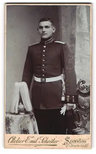 Fotografie Emil Schröter, Spandau, Soldat in Gardeuniform mit Pickelhaube samt Rosshaarbusch auf dem Tisch