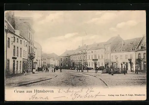 AK Hünshoven, Strassenpartie mit Geschäften und Denkmal