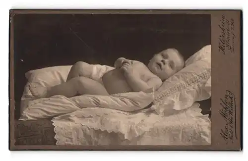Fotografie Alex. Möhlen, Hildesheim, Almsstr. 31, Portrait nacktes Baby auf einem weissen Kissen liegend