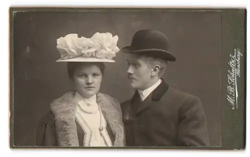 Fotografie M. B. Schultz, Flensburg, Portrait eines elegant gekleideten Paares