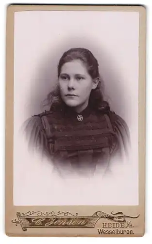 Fotografie C. Jensen, Heide i. H., junge Frau mit zurückgesteckten Haaren im schwarzen Kleid