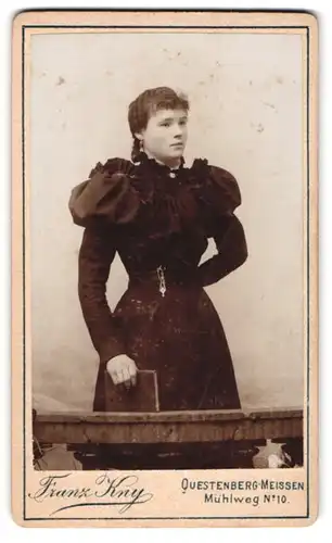 Fotografie Franz Kny, Questenberg-Meissen, Mühlweg 10, junge Dame in schwarz tailliertem Kleid mit imposanten Puffärmeln