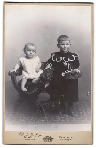 Fotografie Max Wolf, Pforzheim, Schulberg 3, zwei süsse Geschwisterchen posierend mit Flechtkorb