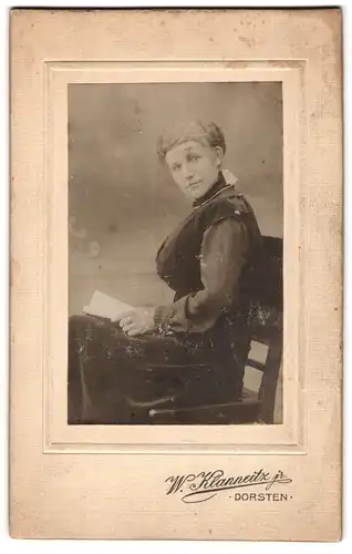 Fotografie W. Klanneitz jr., Dorsten, junge Frau lesend auf einem Stuhl